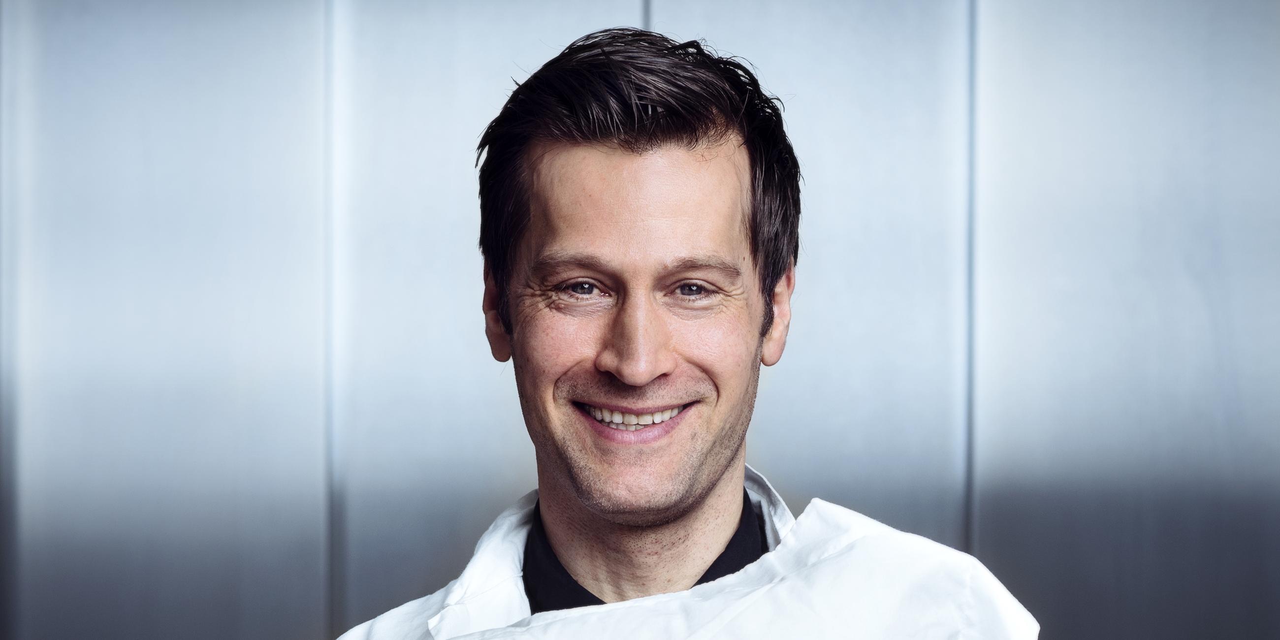 Der Autor und Wissenschaftler Christian Benedict hält ein weißes Kissen.