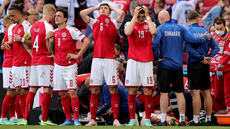 Dänemarks Andreas Christensen und seine Mannschaftskameraden reagieren auf die medizinische Versorgung von Christian Eriksen, der während des Spiels zusammengebrochen ist am 12.06.2021.