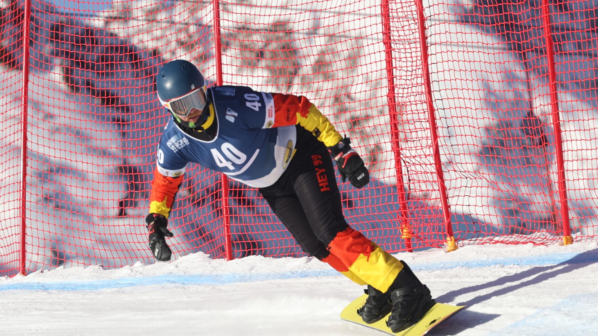 Christian Schmiedt fährt mit dem Snowboard die Piste runter.
