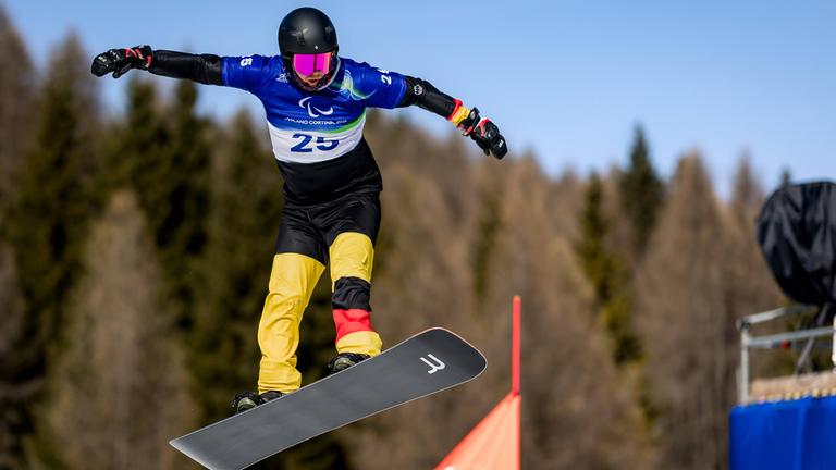Der deutsche Snowboarder Christian Schmiedt springt bei den Paralympics in Cortina d’Ampezzo in Italien vom Hügel ab