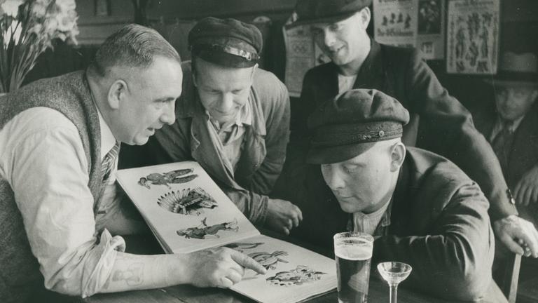 Christian Warlich zeigt Kunden sein Vorlagealbum (ca 1936)