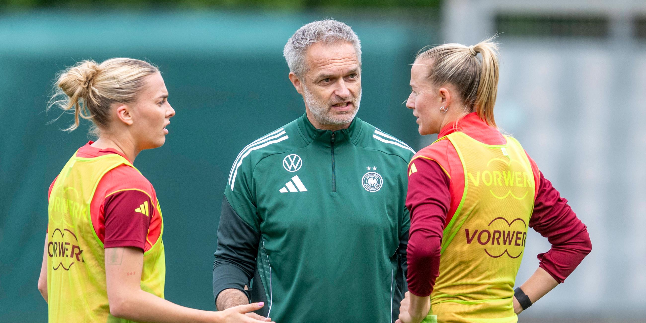 Bundestrainer Christian Wück spricht mit Laura Freigang (l) und Lea Schüller. 
