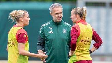 Bundestrainer Christian Wück spricht mit Laura Freigang (l) und Lea Schüller. 