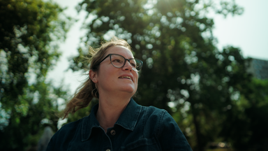 Christiana L. draußen vor einem großen Baum