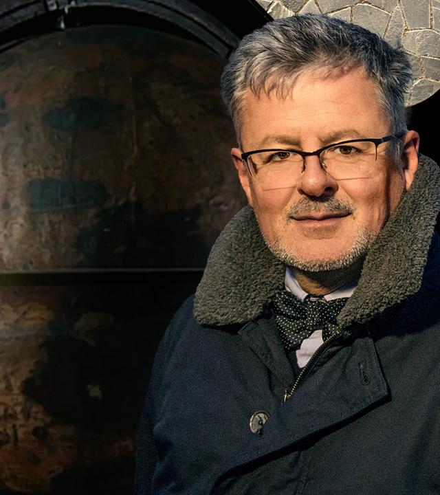 Christopher Clark steht vor einem Globus
