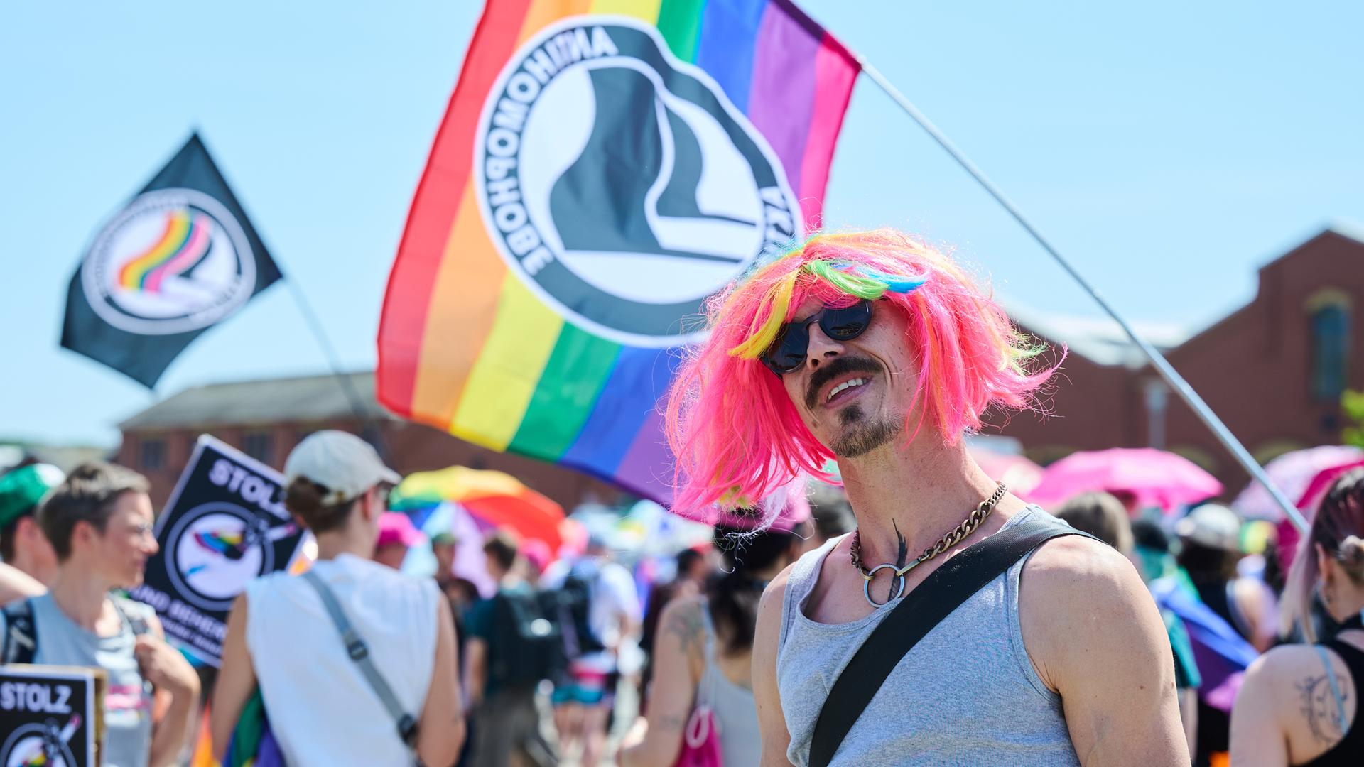 21.06.2025, Brandenburg, Eberswalde: Ein Teilnehmer des CSD (Christopher Street Day) trägt eine bunte Perücke.