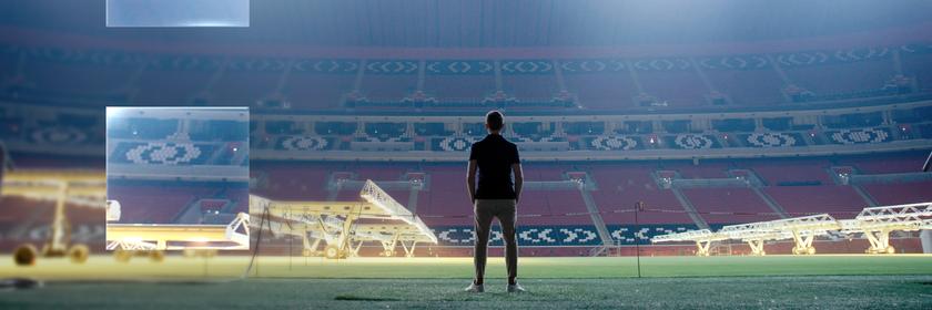 "ZDFzeit: Geheimsache Katar": Blick in ein leeres, hell beleuchtetes Fußballstadion. In der Mitte sind die dunklen Umrisse eines Menschen zu erkennen, der dem Betrachter den Rücken zukehrt