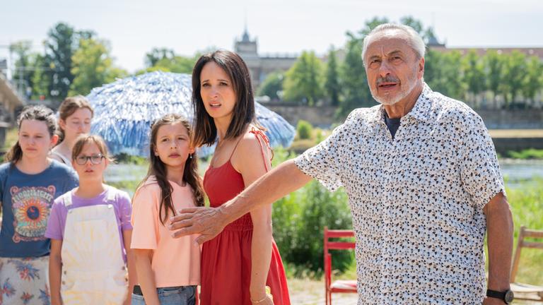 "Stubbe - Familie in Gefahr": Draußen steht Caro Stubbe (Greta Kasalo) neben ihrer Mutter Christiane Stubbe (Stephanie Stumph). Stubbe (Wolfgang Stumph) hält beschützend seinen Arm vor die beiden. Neben ihnen stehen drei Mädchen (Komparsinnen), Gäste der Geburtstagsfeier von Caro.