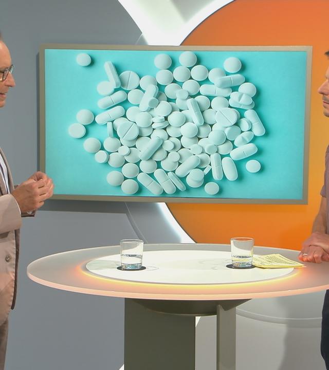Dr. Christoph Specht bei "Volle Kanne" über chronische Schmerzen vor Bildtafel mit Tabletten