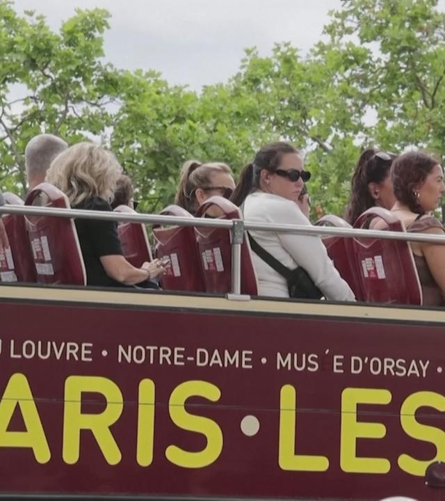 Touristen auf einem offenen Touri-Bus in Paris