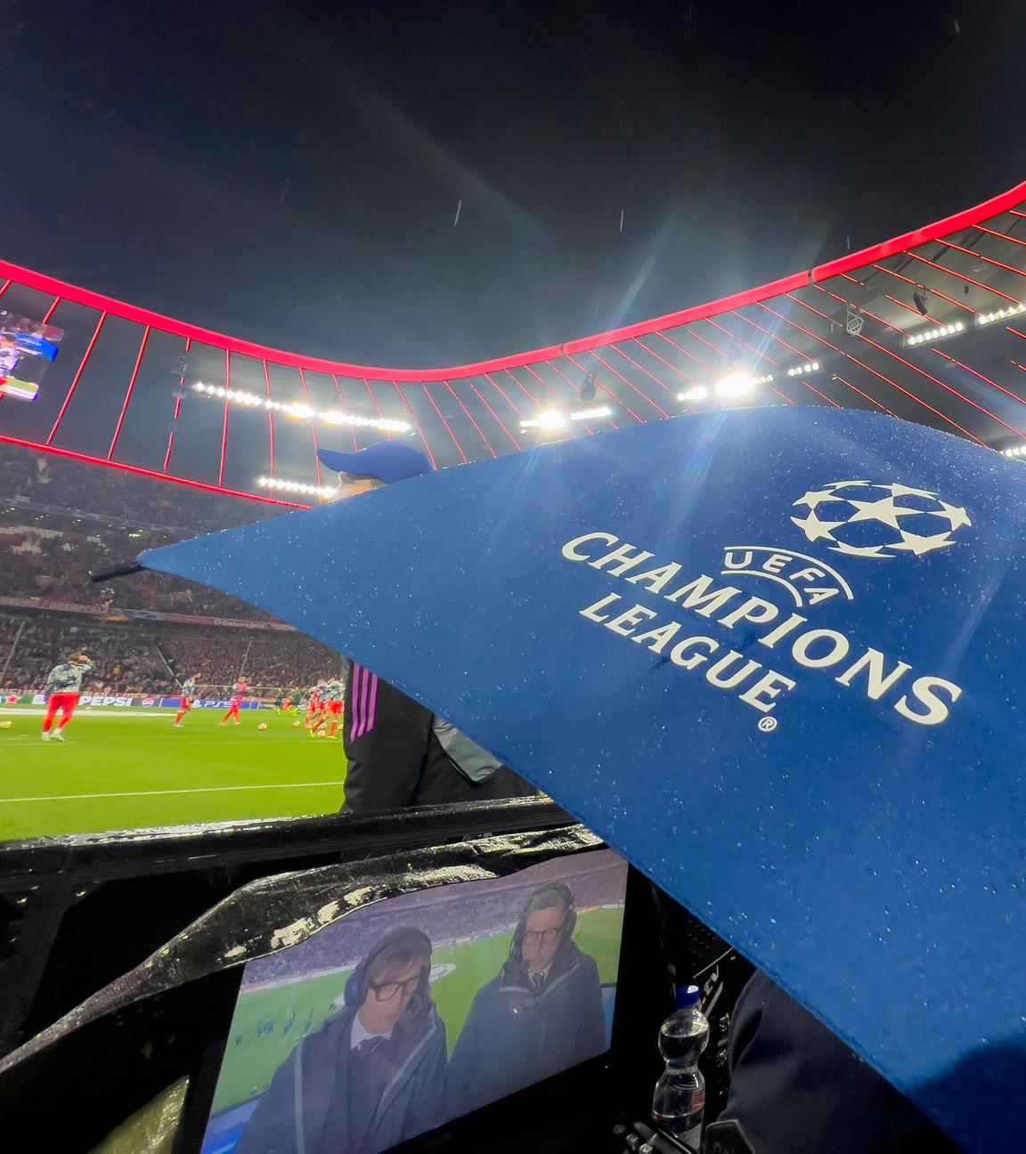 Ein Regenschirm mit dem Champions-League-Logo in der Allianz-Arena München am Spielfeldrand