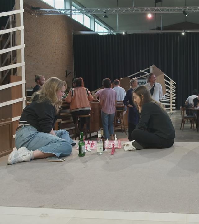 Menschen spielen gemeinsam Schach an mehreren Brettern.
