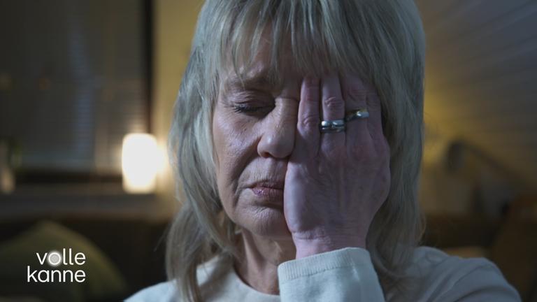 Frau hält sich eine Hand vor Augen. Sie leidet unter Clusterkopfschmerzen.