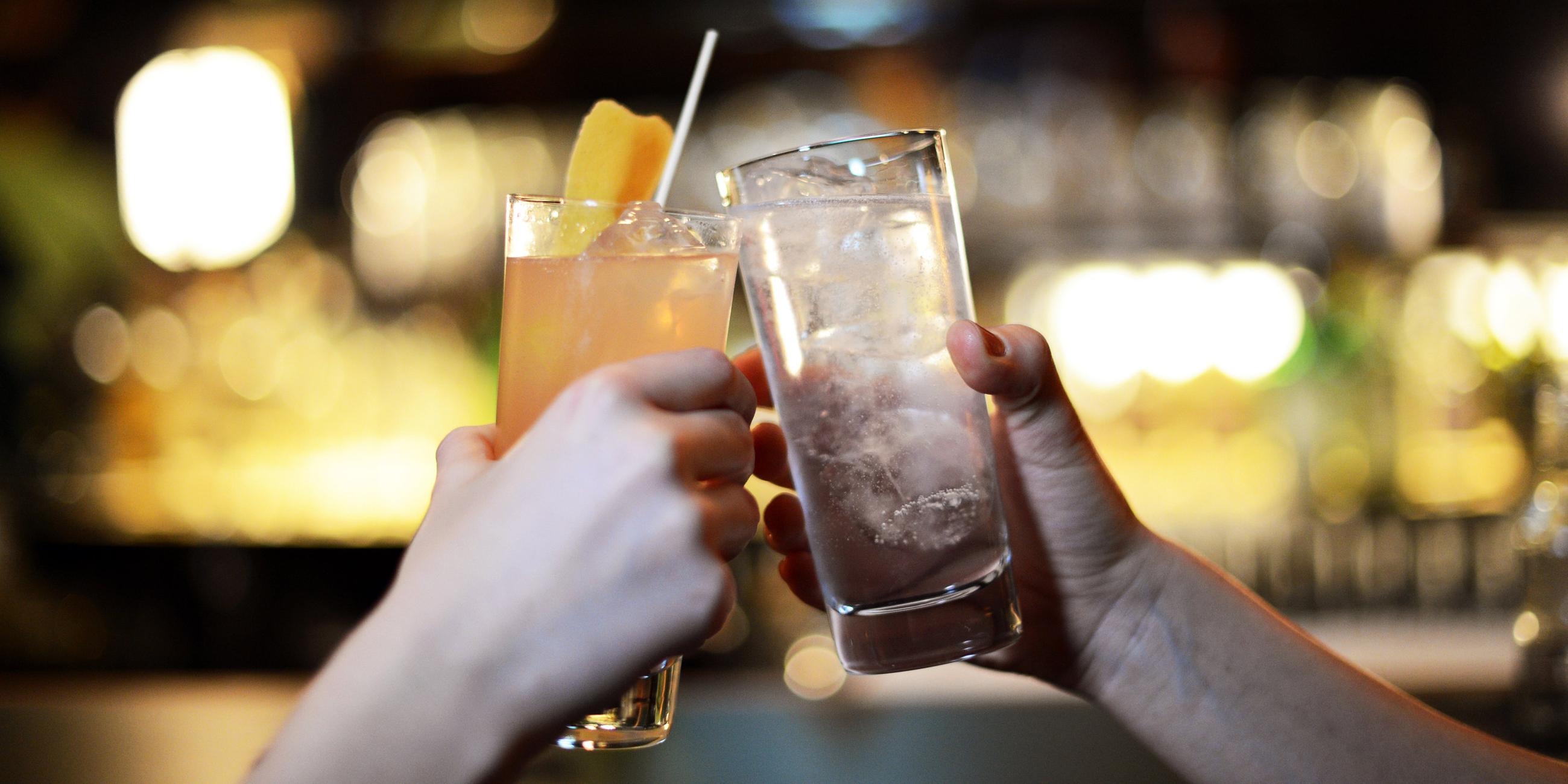 Symbolbild: Gäste stossen mit Ihren Cocktailgetränken in einer Bar an