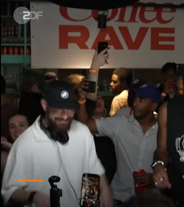 DJs legen beim Coffee Rave in Berlin vor tanzenden Menschen Musik auf. 