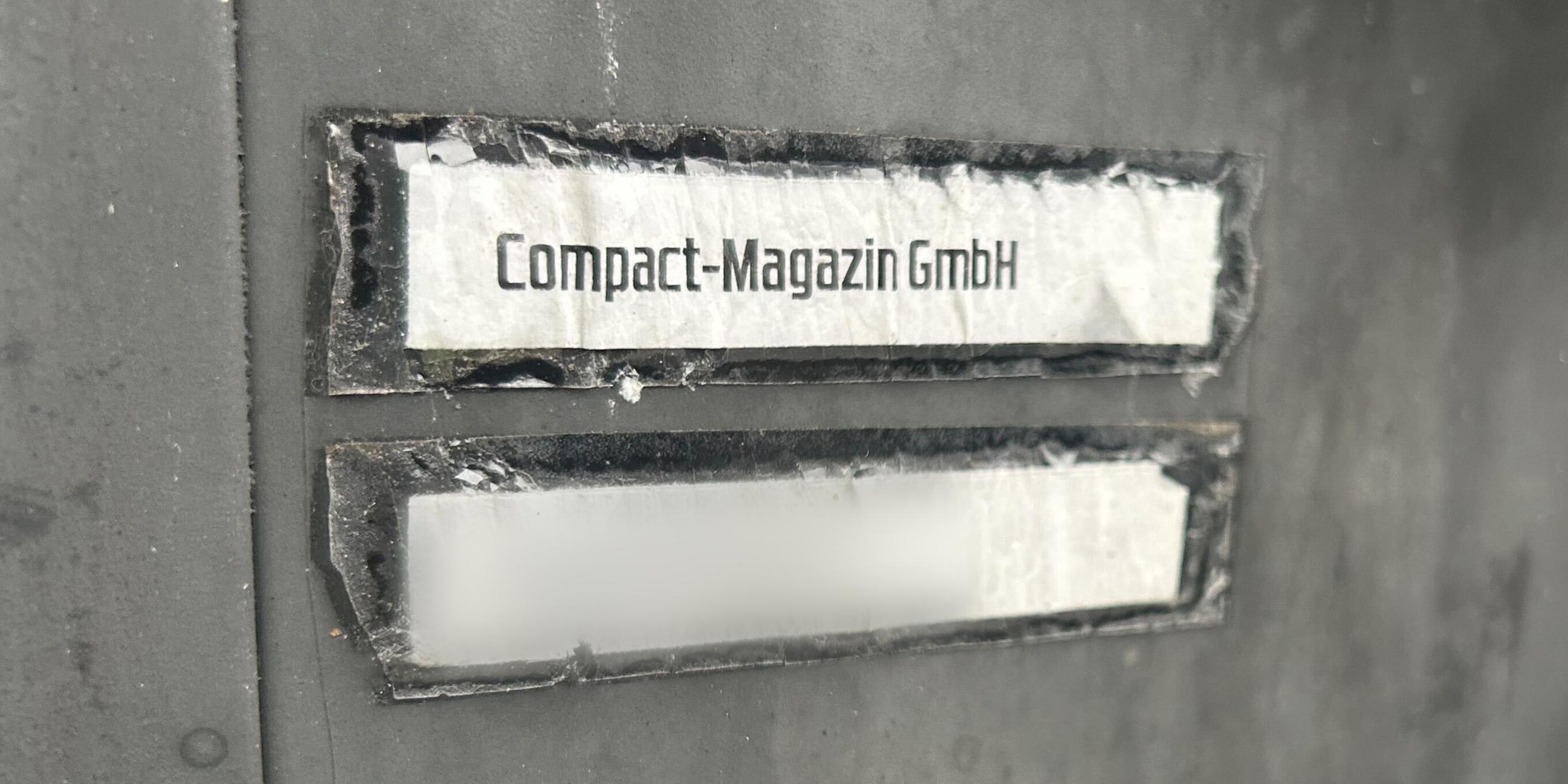 Die Aufschrift "Compact-Magazin GmbH" steht an einem Briefkasten.