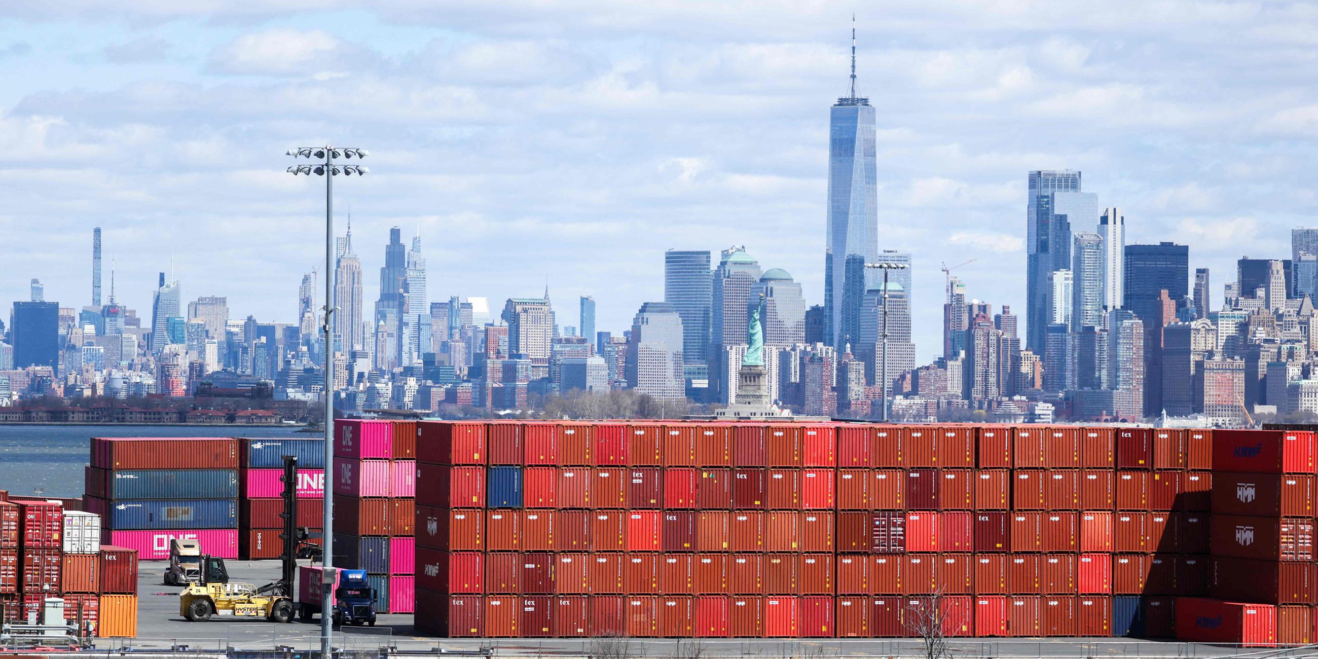 Schiffscontainer sind am 8. April 2025 am Port Jersey Container Terminal in Jersey City, mit der Skyline von Manhattan im Hintergrund.