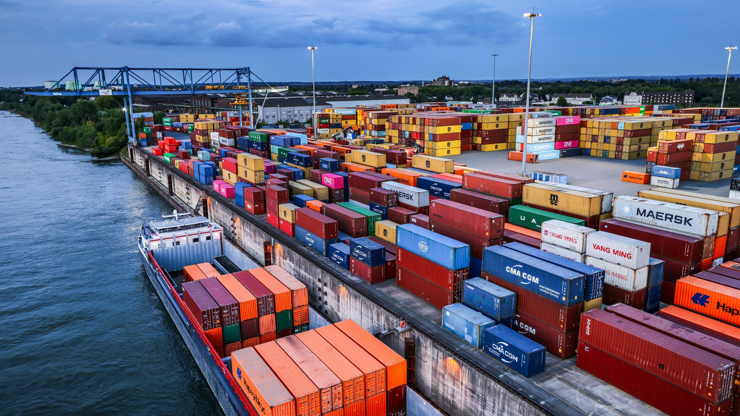 Nordrhein-Westfalen, Duisburg: Container werden im Duisburger Hafen auf Binnenschiffe verladen.