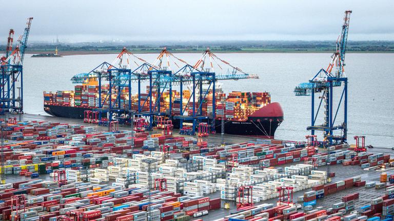 Container und ein Containerschiff liegen im Hafen von Bremerhaven am 14.10.2025.