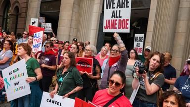Vor allem Frauen demonstrieren mit Plakaten, auf einem steht "We are all Jane Doe"