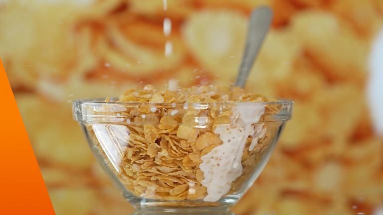 Cornflakes in einer Glasschale mit Milch oder Milchersatzprodukt