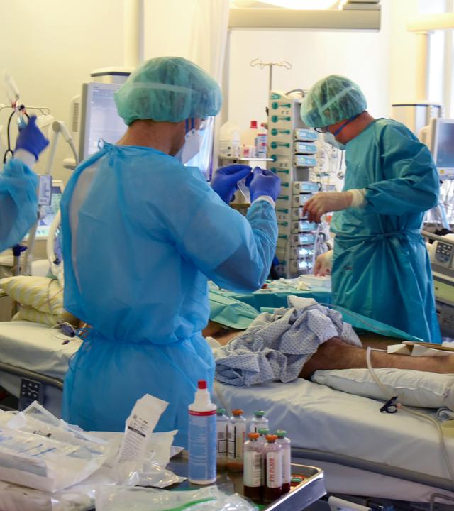 Auf der Covid-Station, einem Bereich der Operativen Intensivstation versorgen Ärzte, Schwestern und Pfleger einen Patienten.