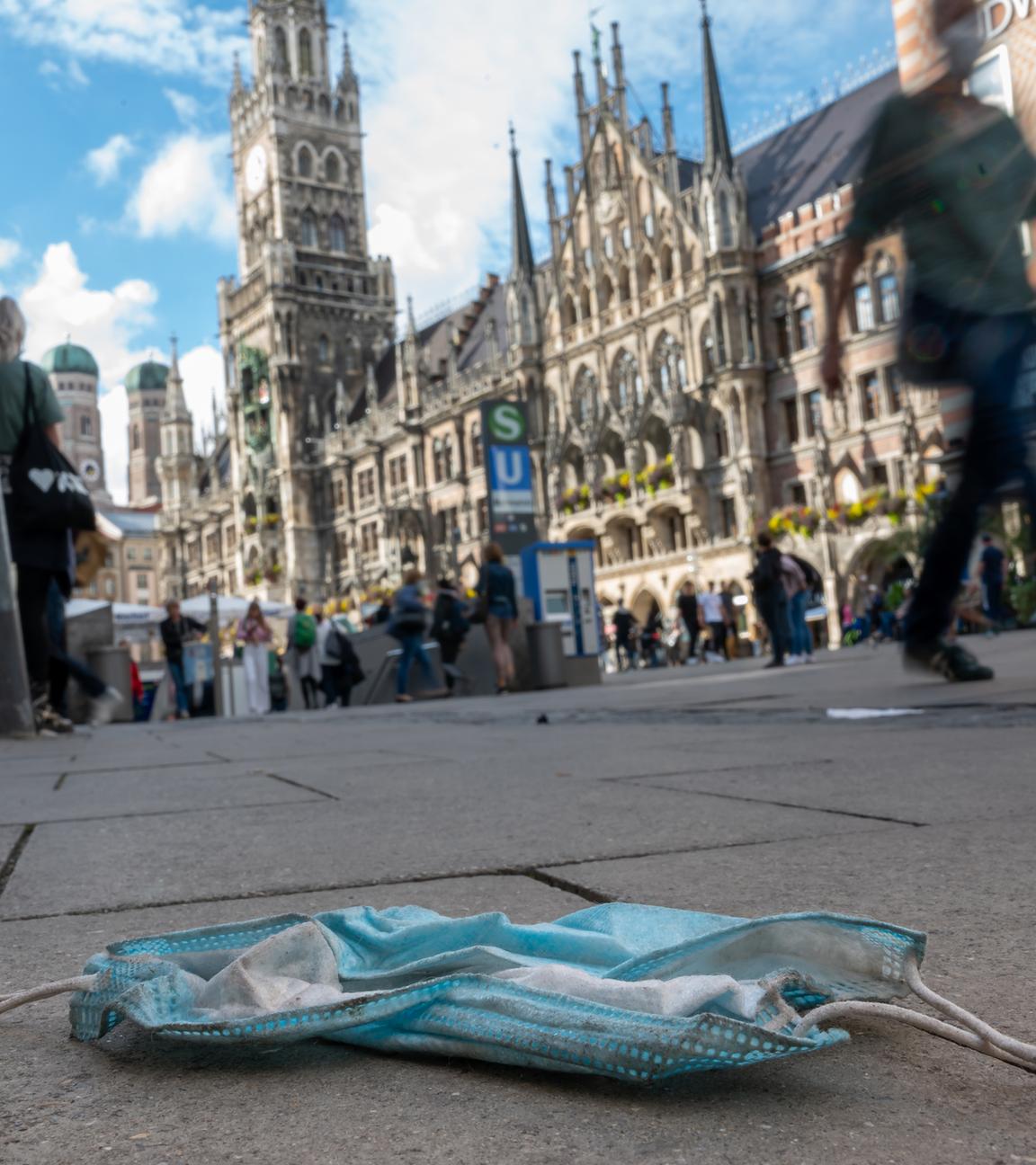 Getragene Maske liegt auf dem Boden in Fußgängerzone am Rathaus in München