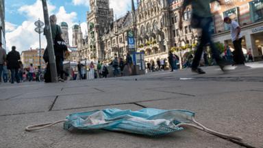 Getragene Maske liegt auf dem Boden in Fußgängerzone am Rathaus in München
