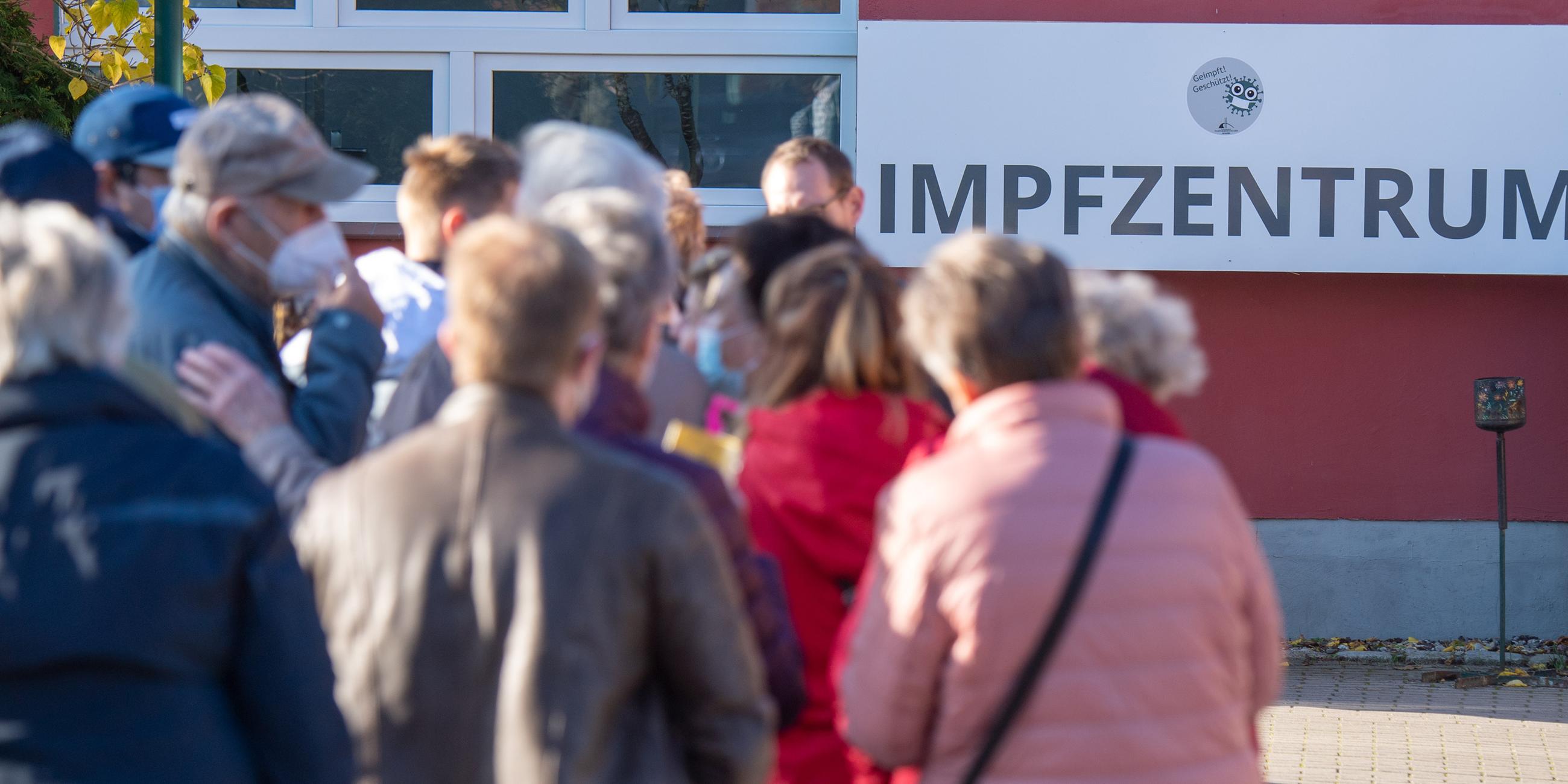 Symbolbild: Im Vordergrund warten Impflinge auf einen Termin für eine Booster-ImpfungSchild am Corona-Impfstützpunkt des Landkreis Vorpommern-Rügen in Stralsund