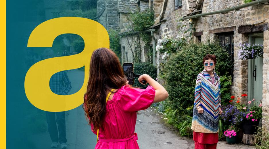 Eine Frau fotografiert eine andere Frau vor einem alten schönen englischen Cottage
