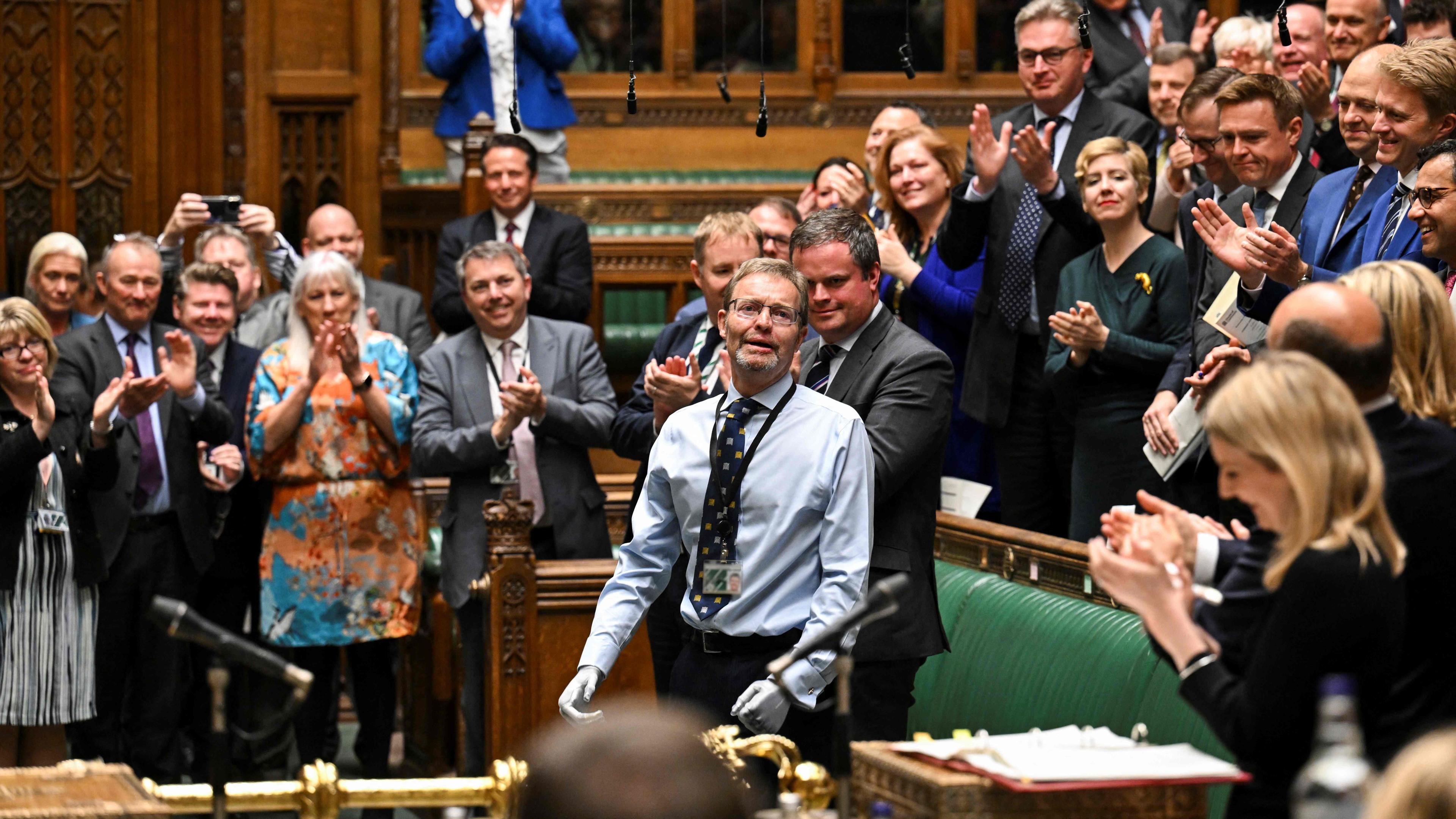 Ein vom britischen Parlament veröffentlichtes Handout-Foto zeigt den konservativen britischen Abgeordneten Craig Mackinlay, der zu Beginn der wöchentlichen Fragestunde des Premierministers im Unterhaus im Zentrum Londons am 22. Mai 2024, dem Tag seiner Rückkehr, Beifall und Jubel entgegennimmt. Craig Mackinlay kehrt am 22. Mai 2024 zum ersten Mal ins britische Parlament zurück, nachdem ihm nach einer Sepsiserkrankung beide Hände und Füße amputiert wurden. Mackinlay wurde im September letzten Jahres ins Krankenhaus eingeliefert und verbrachte 16 Tage in einem künstlichen Koma, bevor ihm im Dezember eine vierfache Amputation durchgeführt wurde.