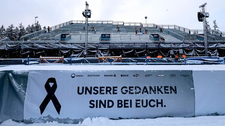 Ein Banner mit der Aufschrift "In Gedanken bei euch" während des Audi FIS Ski World Cup 2025-26 in Crans Montana, Schweiz.