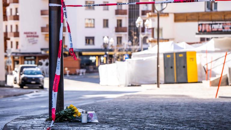 Ein Foto vom 01.01.2026 zeigt Blumen und Kerzen, die nach einer Explosion, die den Veranstaltungsort in Crans-Montana während der Silvesterfeierlichkeiten erschütterte, in der Nähe der Bar "Le Constellation" auf den Boden gelegt wurden. 