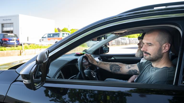 Niklas Schweitzer sitzt am Steuer eines Autos der Fahrschule. Sein Fahrlehrer Axel Steinadler sitzt neben ihm.