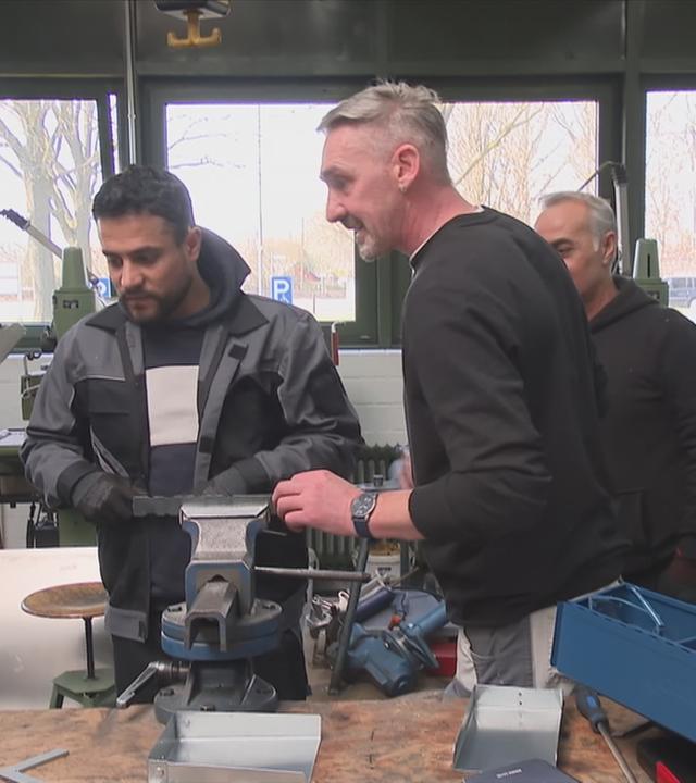 Drei Männer in Werkstatt