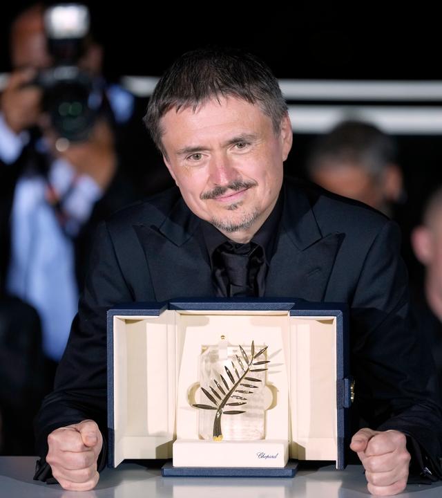 Cristian Mungiu und die vor ihm stehende Goldene Palme.