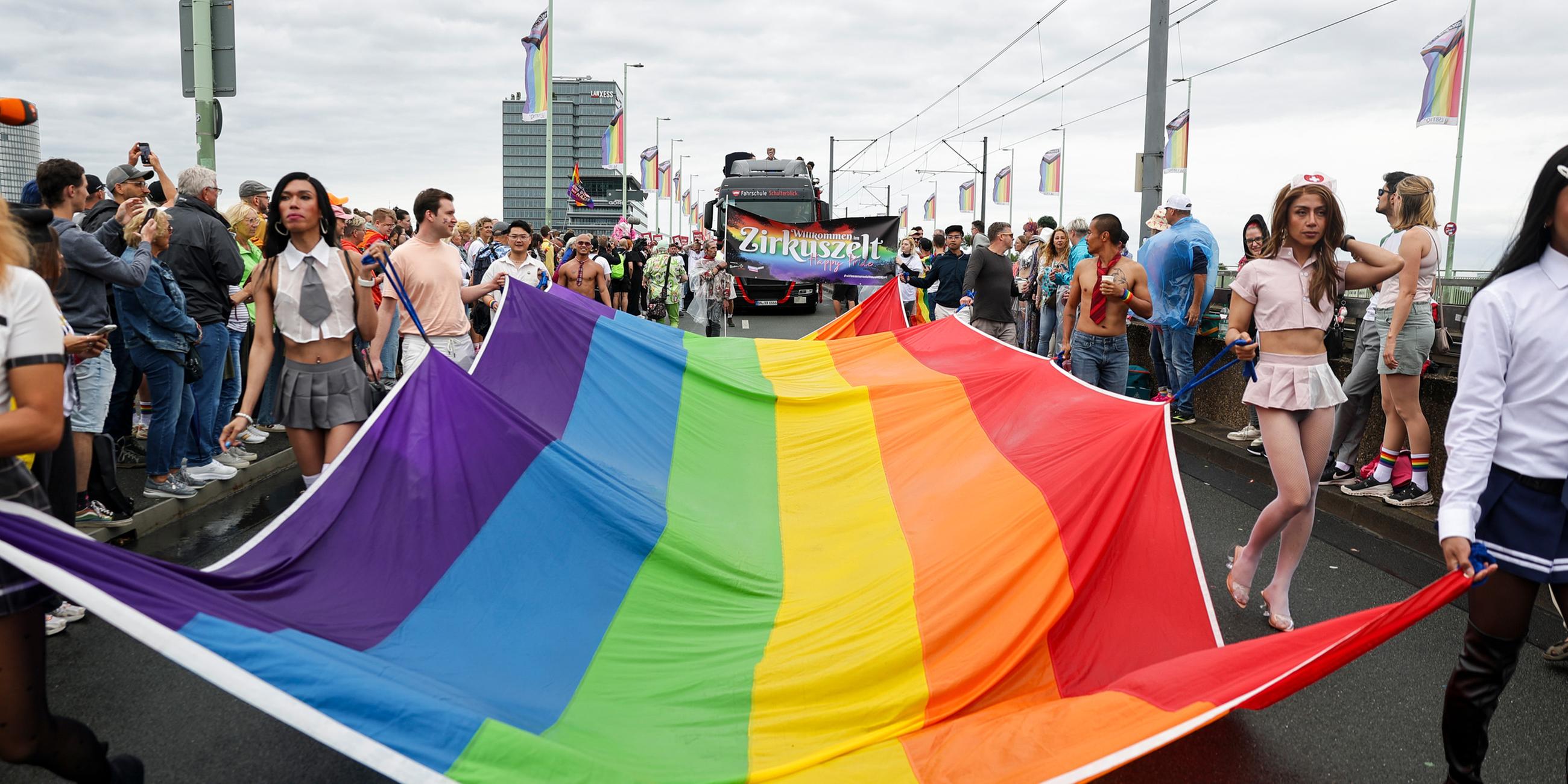 Teilnehmer des Christopher Street Days in Köln tragen eine Regenbogenflagge. Aufgenommen am 06.07.2025.
