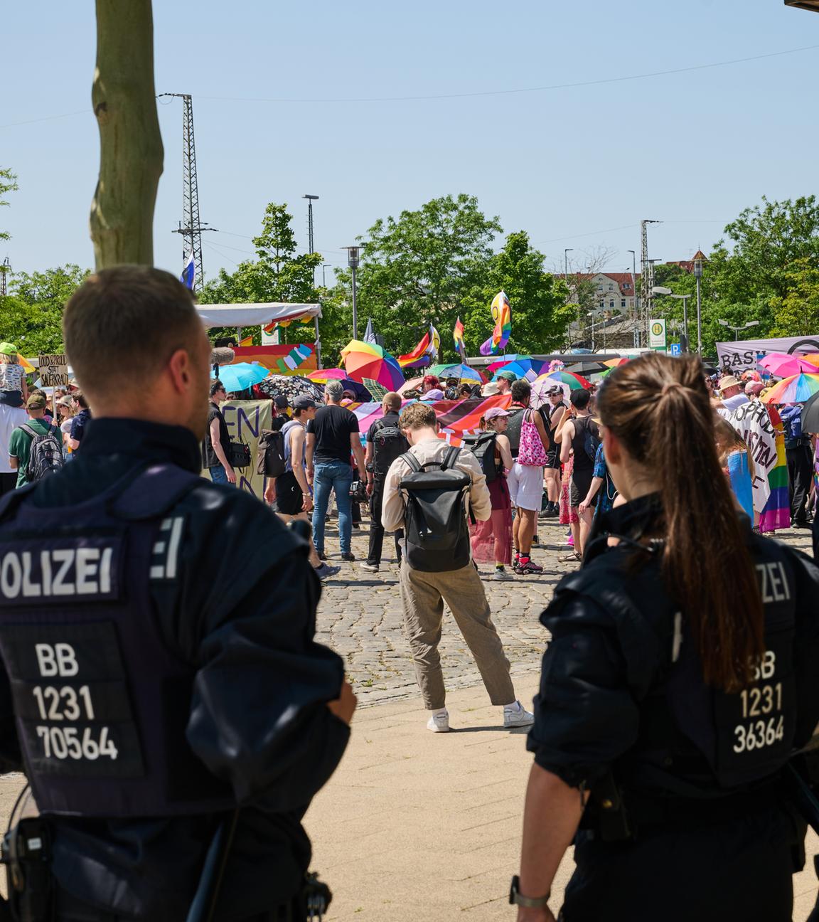 21.06.2025, Brandenburg, Eberswalde: Teilnehmer am Christopher Street Day (CSD) halten Regenbogenschirme, während sie unter Politzeischutz nach dem Motto "Wir lassen uns nicht vertreiben" demonstrieren.