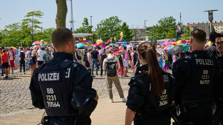21.06.2025, Brandenburg, Eberswalde: Teilnehmer am Christopher Street Day (CSD) halten Regenbogenschirme, während sie unter Politzeischutz nach dem Motto "Wir lassen uns nicht vertreiben" demonstrieren.