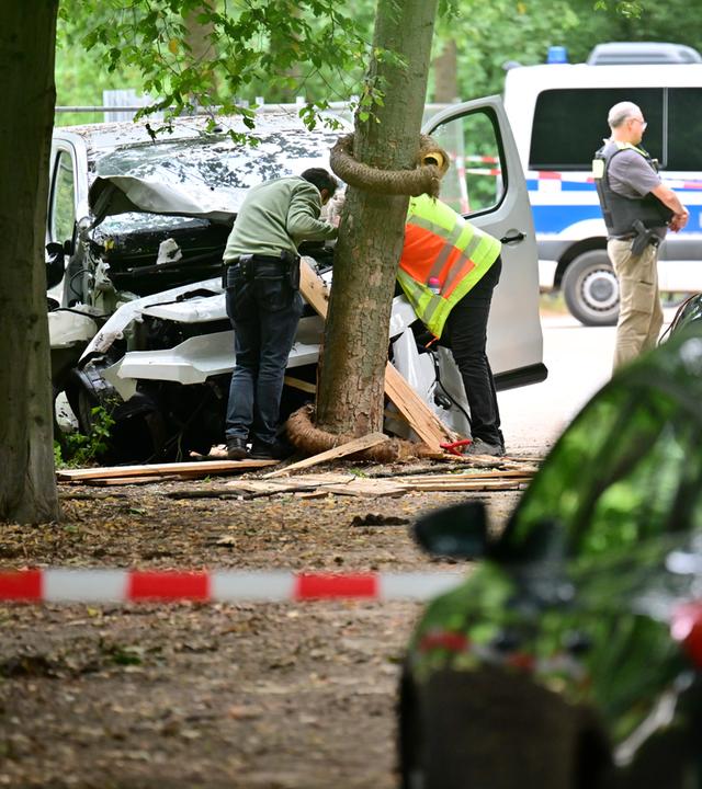 Mitarbeiter der Unfallforschung betrachtet das Fahrzeug, das in einem Baum im Bereich des Tiergartens gefahren ist.