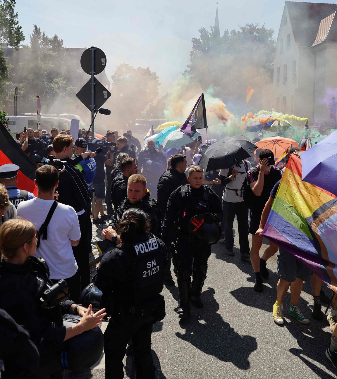 Neben der CSD-Parade ist eine Gegendemonstration. In der Mitte stehen Polizisten
