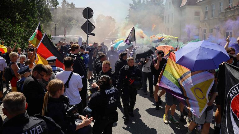 Neben der CSD-Parade ist eine Gegendemonstration. In der Mitte stehen Polizisten
