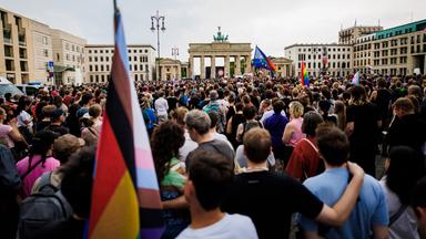 Menschen trauern und demonstrieren vor dem Brandenburger Tor.