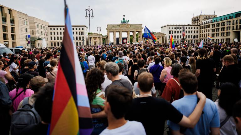 Menschen trauern und demonstrieren vor dem Brandenburger Tor.