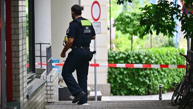 Ein Polizeibeamter geht an den Wohnblöcken vorbei, in denen  in der Nacht eine Wohnung durchsucht wurde. 