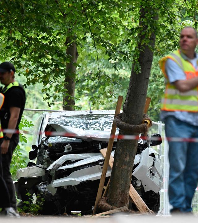 Polizeibeamte stehen am 26. 7. 2026 nahe dem Auto, das – wie behauptet – in eine Menschenmenge gesteuert wurde