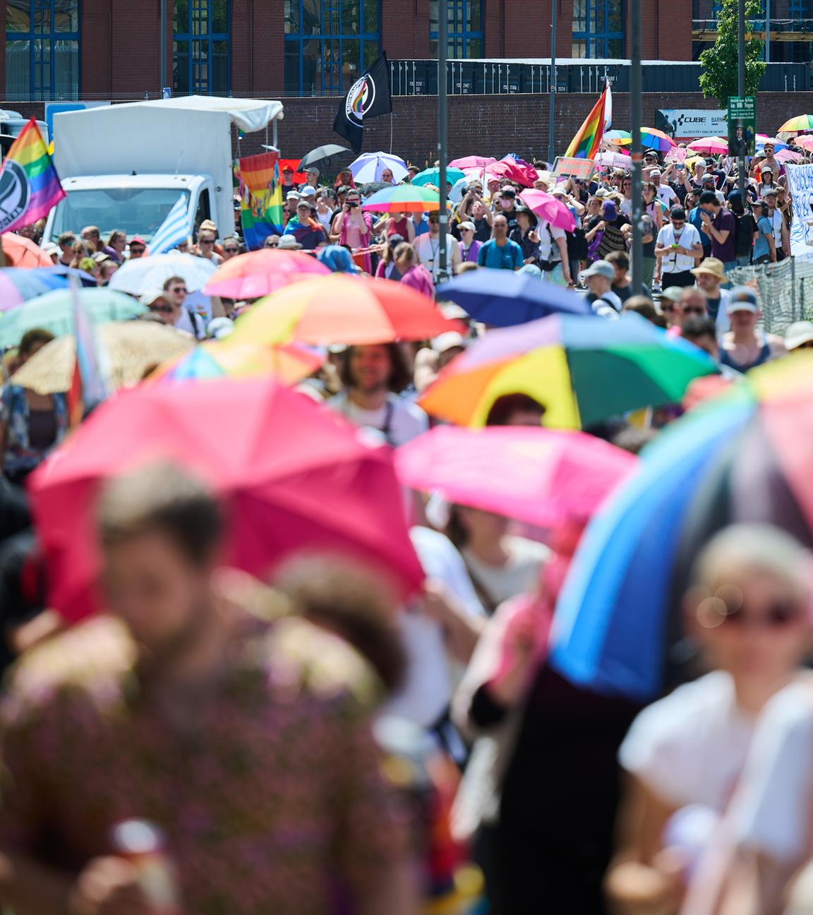 Teilnehmer am Christopher Street Day (CSD) halten Regenbogenschirme, während sie unter Politzeischutz nach dem Motto Wir lassen uns nicht vertreiben demonstrieren.