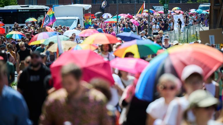 Teilnehmer am Christopher Street Day (CSD) halten Regenbogenschirme, während sie unter Politzeischutz nach dem Motto Wir lassen uns nicht vertreiben demonstrieren.