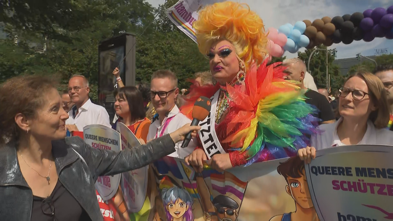 ZDF-Reporterin Petra Meier interviewt Dragqueen Olivia Jones auf dem Hamburger CSD. Olivia Jones trägt ein Outfit in Regenbogenfarben.