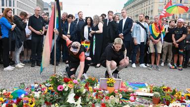 People mourn in front of the Brandenburg Gate after taking part in a mourning march near the scene where a vehicle was driven into a crowd beside the Christopher Street Day (CSD) parade route in Berlin.